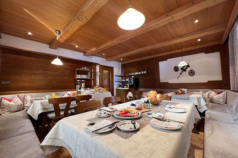 Frühstücksraum mit gedeckten Tischen im Petererhof