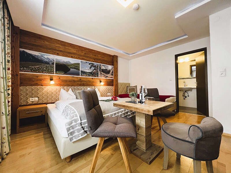 Seating with table and chairs in front of the double bed in room 3