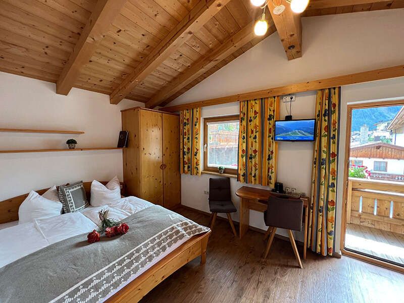 Room 5 with double bed, seating area and balcony